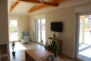 ein Wohnzimmer mit einem Flachbild-TV und einem Stuhl in der Unterkunft Lifestyle Ferienhaus in Pouch