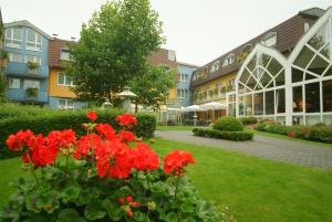 a courtyard with red flowers in front of a building at Straelener Hof in Straelen