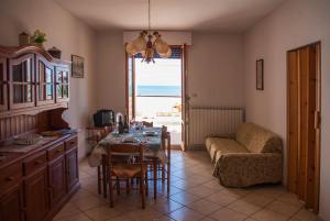 un soggiorno con tavolo e divano di Appartamento di Antonio fronte Mare a Montesilvano