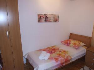 Apartman Helen في مالينسكا: غرفة نوم صغيرة عليها سرير وفوط