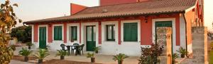 Una pequeña casa con persianas verdes. en Agriturismo Arangèa, en Lequile