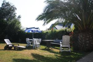 a group of chairs and a table and an umbrella at Pension de Kerioual in Roscoff