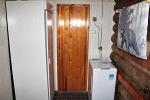 a bathroom with a toilet and a wooden door at Mäntyrinne in Syöte +37 photos