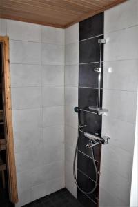 a shower in a bathroom with black and white tiles at Mäntyrinne in Syöte
