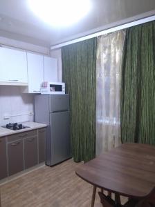 cocina con mesa y cortina verde en Просторная 1комнатня квартира напротив ТРЦ Дафи Ашан рядом ресторан Альтбир, en Járkov
