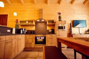 a large kitchen with wooden cabinets and a wooden table at Ferienhaus Orchidee in Rieden