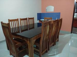uma sala de jantar com uma mesa e quatro cadeiras em Royal Munroe Palace Home Stay em Munroe Island