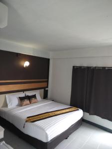 a bedroom with a large bed with a black headboard at NorthLands House Hotel in Chiang Mai