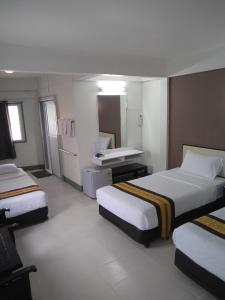 une chambre d'hôtel avec deux lits et un lavabo dans l'établissement NorthLands House Hotel, à Chiang Mai