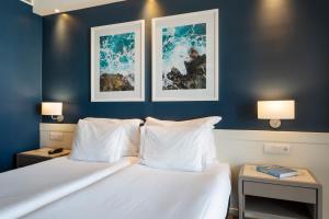 a hotel room with two beds and a painting on the wall at AP Eva Senses in Faro