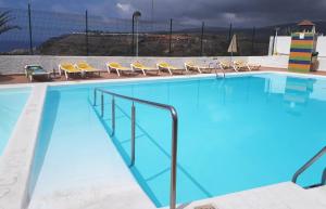 una grande piscina con sedie di APT with terrace facing Amadores beach ad Amadores