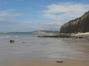 una playa con rocas y agua y el océano en LA MENUISERIE D'ANDRE en Gueures