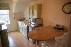 a kitchen with a table and a clock on the wall at Harrogate Elite Living in Harrogate