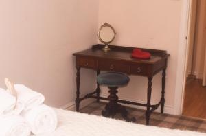 ハロゲートにあるHarrogate Elite Livingのベッドの横に鏡付きの化粧台