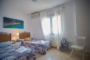 - une chambre avec 2 lits et une fenêtre dans l'établissement Villa 25, à Mutxamel