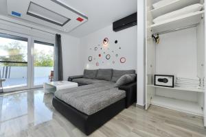 ein Wohnzimmer mit Couch und Fernseher in der Unterkunft Villa Lily ZadarVillas in Privlaka