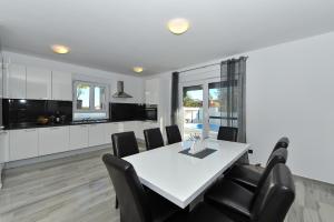 eine Küche und ein Esszimmer mit einem weißen Tisch und Stühlen in der Unterkunft Villa Lily ZadarVillas in Privlaka