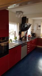 a kitchen with red cabinets and a sink at Oestermark in Ærøskøbing