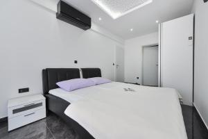 ein Schlafzimmer mit einem weißen Bett mit einem schwarzen Kopfteil in der Unterkunft Villa Lily ZadarVillas in Privlaka + 33 Fotos