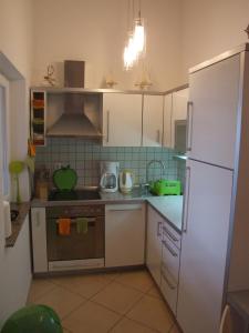 a kitchen with a white refrigerator and a stove at Apartman Helen in Malinska