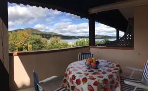a table with a bowl of fruit on a balcony at Sardegna Beach Cala Reale in Santa Marinella
