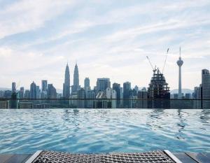 a swimming pool on the roof of a building with a city skyline at Maxhome@Regalia suite residence. KL in Kuala Lumpur