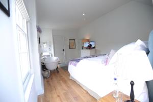 a bedroom with a bed and a bathroom with a sink at Bel and The Dragon-Kingsclere in Kingsclere