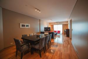 a dining room with a black table and chairs at ARC Callao Studios & Suites in Buenos Aires