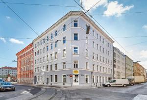 een wit gebouw met auto's ervoor geparkeerd bij Twin Apartment in Wenen
