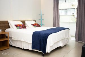 ニテロイにあるIcaraí Suítesのベッドルーム1室(白いシーツと枕のベッド1台付)