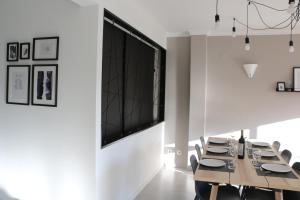 een eetkamer met een grote televisie aan de muur bij Lagos Beach 59A in Lagos +5 foto's