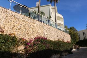 een steunmuur met bloemen en een gebouw bij Lagos Beach 59A in Lagos