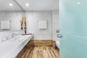 a white bathroom with a sink and a toilet at Iris Hotel in Siviri