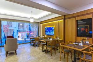 un restaurante con paredes de madera, mesas y sillas en Obelisk Hotel & Suites, en Estambul