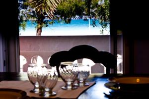 a table with wine glasses on a table with a view of the ocean at La Villa Della Meda in Taranto