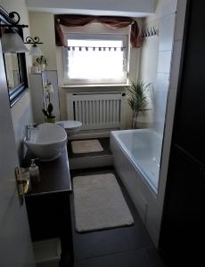 uma casa de banho com uma banheira, um lavatório e um WC. em Randersacker em Randersacker