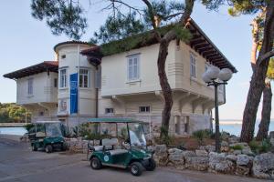 a golf cart parked in front of a building at Brijuni Rooms Karmen in Fažana