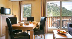 ein Esszimmer mit einem Tisch und Stühlen sowie einem Balkon in der Unterkunft Résidence mmv Les terrasses d'Isola in Isola 2000