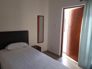 a bedroom with a bed and a sliding glass door at Fama Lodge Single Rooms in Cape Town