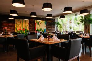 フォス・ド・イグアスにあるVivaz Cataratas Hotel Resortのテーブルと椅子、大きな窓のあるレストラン