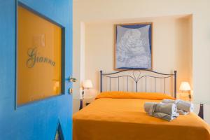 a bedroom with a bed with orange sheets and a blue door at Palazzo Cocò Sentiero dei Limoni in Maiori