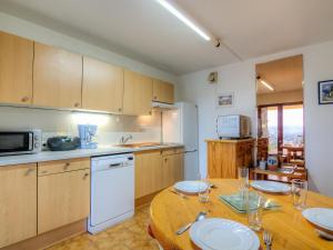 une cuisine avec une table en bois et des plaques de cuisson. dans l'établissement Apartment Les Jardins d'Azur by Interhome, à Cavalaire-sur-Mer