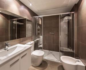 a bathroom with a sink, toilet and bathtub at Mon Suites Catedral in Valencia