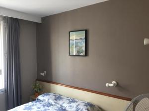 1 dormitorio con 1 cama y una foto en la pared en Hôtel du Sud Vieux Port, en Marsella