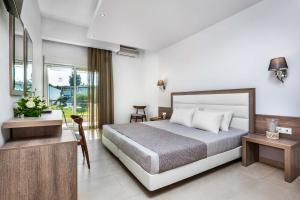 a hotel room with a bed and a desk at Iris Hotel in Siviri