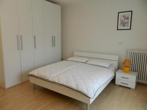 a bedroom with a white bed and a white cabinet at Sun in Nago-Torbole +14 photos