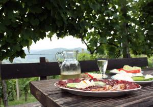 a wooden table with plates of food and a pitcher of water at Masnec Tourist Farm in Miljana