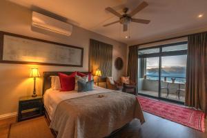 a bedroom with a bed with a view of the ocean at Mariner Guesthouse & Villa in Simonʼs Town