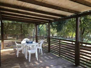 une table et des chaises blanches sur une terrasse en bois dans l'établissement Mobile Homes Comfort CAPRI Bijela Uvala, à Poreč