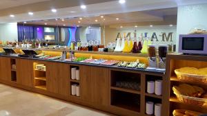 a restaurant with a counter with food on it at MARİNA HOTEL in İzmir